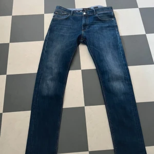 Blå jeans från Massimo Dutti - Snygga blå jeans från Massimo Dutti med klassisk femficksdesign och skinnpatch bak. Jeansen har en rak passform och subtila slitningar framtill för en cool look. Perfekta till sneakers eller boots.