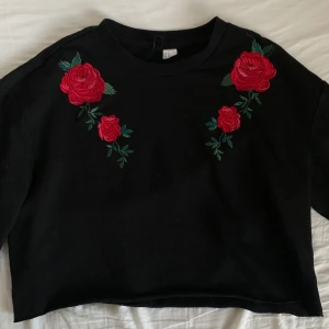 svart topp med trekvartsärm  - Fin topp med trekvartsärm och broderade rosor! Toppen är ganska oversized och lite croppad. I bra skick, bara använd 1-2 gånger. Pris kan diskuteras 🌹 