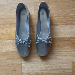 Silvriga ballerinaskor från H&M - Snygga ballerinaskor i  silver från H&M. Endast prövade inomhus så är i nyskick!! Så fina och puffar upp en outfit!