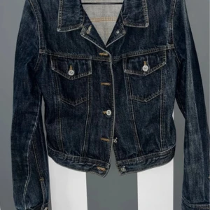 Katharine Hamnett jeansjacka retro - Klassisk mörkblå jeansjacka med snygga kontrastsömmar och silverfärgade knappar. Jackan har två bröstfickor med lock och knappar, samt en rak passform. Perfekt att slänga över en hoodie eller t-shirt för en cool look.Bra beg skick  Stl XS Har lite färgskiftning på axlarna se bilder