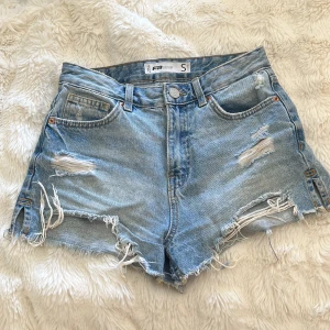 Ljusa jeansshorts med slitningar - Skit snygga jeans shorts med slitningar. Mid waist. 
