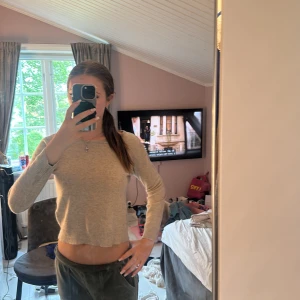 Beige stickad tröja från Indiska - Supermjuk beige stickad tröja från Indiska med rund halsringning och ribbade muddar. Modellen är croppad och har långa ärmar, perfekt att styla med jeans eller kjol. Enkel och stilren design som funkar året runt.