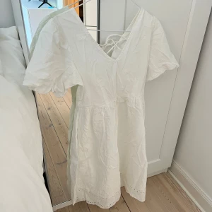 Vit sommarklänning - Superfin vit kortklänning med puffärmar, broderade blommor och v-ringning. Klänningen har snörning i ryggen och är gjord i bomull, perfekt för vardags, fest med klackar eller stranden 🩷🩷 stretchig så passar XS-M, använd 1 gång