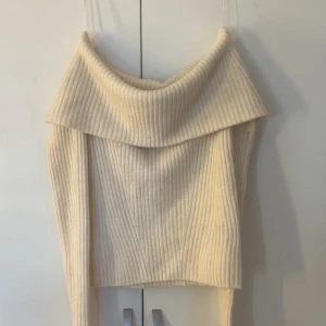 Offshoulder ribbad tröja H&M XS - Superfin offshoulder tröja från H&M i ribbstickad beige ullmix. Tröjan har bred krage som vilar snyggt över axlarna och långa ärmar. Perfekt för dig som gillar en stilren och mysig look med trendig twist.