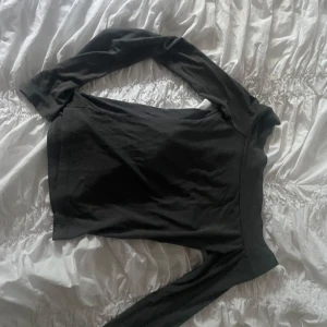 Grå offshoulder långärmad topp - Säljer en grå långärmad topp med offshoulder-modell. Snygg och enkel design som sitter tight och har en bred halsringning. Perfekt att styla med jeans eller kjol för en clean look.