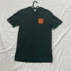 T-shirt  - Grön T-shirt. Storlek S. Med tryck fram och bak. 