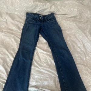 Bootcut jeans från Gina Tricot blå - Mörkblå bootcut jeans från Gina Tricot i klassisk denim. Byxorna har fem fickor, normal passform över låren och utsvängda ben. Perfekta för dig som gillar en retroinspirerad look. Snygga till sneakers eller boots.