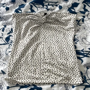 Vit blommig tubtopp från Divided - Supersöt vit tubtopp från H&M med små svarta blommor över hela toppen. Toppen har en lätt twistad detalj framtill. Perfekt för varma dagar och enkel att styla med jeans eller kjol. ❤️