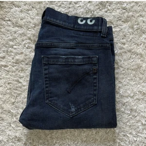 Dondup jeans - Snygga mörkblå jeans från Dondup i modellen George med slitningar på låren. Skick: 8/10 Använt men mycket bra skick. Storlek 33. Har ni några frågor eller funderingar är det bara att fråga på! inget fast pris så kom med förslag!