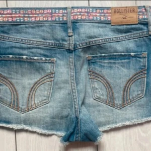 Vintage low rise Hollister micro shorts - Snygga low rise denim shorts från Hollister med råa kanter, mönstrat band i midjan och klassiska bakfickorna. Från 2000-talet 💖