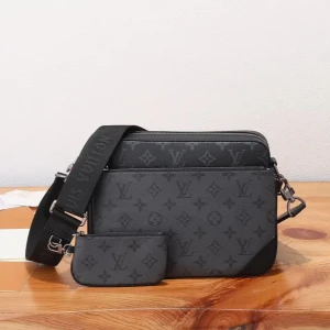 Louis Vuitton svart axelväska - Snygg svart axelväska från Louis Vuitton med klassiskt monogrammönster i mörkgrått. Väskan har bred justerbar axelrem, flera fack med dragkedja och matchande mindre pouch. Tillverkad i skinn med silverfärgade metalldetaljer och LV-logga på dragkedjorna. Pris går att diskutera vid snabb affär!