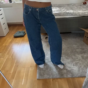 Marinblåa straights jeans från NA-KD - Säljer ett par marinblåa jeans från NA-KD. Jeansen har normal midja och är tillverkade i ett robust denimtyg som ger en snygg och avslappnad look. Perfekta för dig som gillar en trendig och bekväm stil. Storlek 38. Avklippa ca 5cm. Säljar pga för stora, aldrig använda.