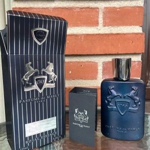 Parfums de Marly Layton 125ml - Exklusiv parfym från Parfums de Marly, Layton Royal Essence. Flaskan är mörkblå med silverdetaljer och har en stilren, maskulin design med två upphöjda hästar och sköld. Kommer i originalförpackning med tillhörande informationshäfte. Volym: 125 ml. priset ej hugget i sten vid snabbaffär 