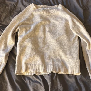 Beige stickad tröja från ONLY - Mysig beige stickad tröja från ONLY med rund halsringning och ribbade muddar vid ärmslut och nederkant. Perfekt för lager-på-lager och enkel att matcha med jeans eller kjol. Klassisk och stilren modell som funkar året runt.