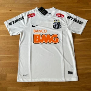 Santos Fc 2012 hemmatröja - Hej, Jag säljer en helt ny med prislapp Santos FC 2012 hemmatröja .  Tveka inte att kontakta mig om du undrar något.  Mvh: JerseyZone 