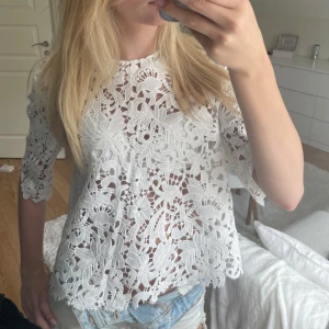 Vit spetsblus från Zara Woman - Superfin vit blus från Zara Woman i genombruten spets med blommigt mönster. Blusen har halvlånga ärmar och rund halsringning. Perfekt för dig som gillar romantisk och trendig stil. Säljs i storlek S. Mycket bra skick avklippt längst ner. Säljer då den inte används 💓