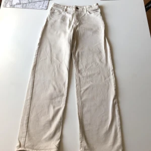 Beige raka jeans från Lindex, stl 146 - Snygga beige jeans från Lindex i rak modell. Klassisk femficksdesign och normal passform. Perfekta till en chill vardagslook och lätta att matcha med det mesta. Tillverkade i bomull för en skön känsla hela dagen.