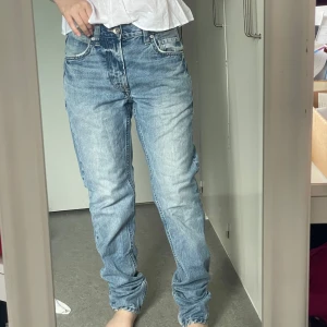 Ljusblå raka jeans - Säljer ett par ljusblå jeans med klassisk femficksdesign och raka ben. Jeansen har en avslappnad passform och är tillverkade i bomull. Perfekta för dig som gillar en chill och enkel stil.