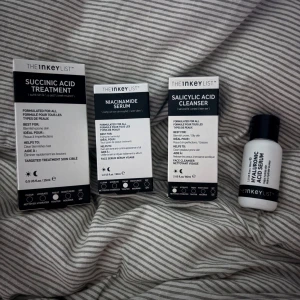 Hudvårdsset från The Inkey List - Säljer ett kit med fyra produkter från The Inkey List: Succinic Acid Treatment 15ml, Niacinamide Serum 30ml, Salicylic Acid Cleanser 60ml och Hyaluronic Acid Serum 30ml. Alla produkter är i svartvita förpackningar och passar perfekt för dig som vill ha en enkel och effektiv hudvårdsrutin.