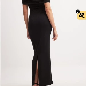 Svart offshoulder långklänning - Elegant svart långklänning med offshoulder-design och slits. Perfekt för en stilren look.