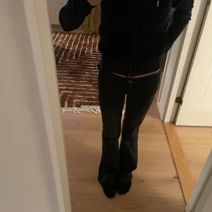 Svart Juicy couture tröja med dragkedja - Snygg svart juicy med dragkedja framtill. Perfekt för en avslappnad stil. Den har långa ärmar och en bekväm passform.Inte använd så många gånger mest under bilresor.