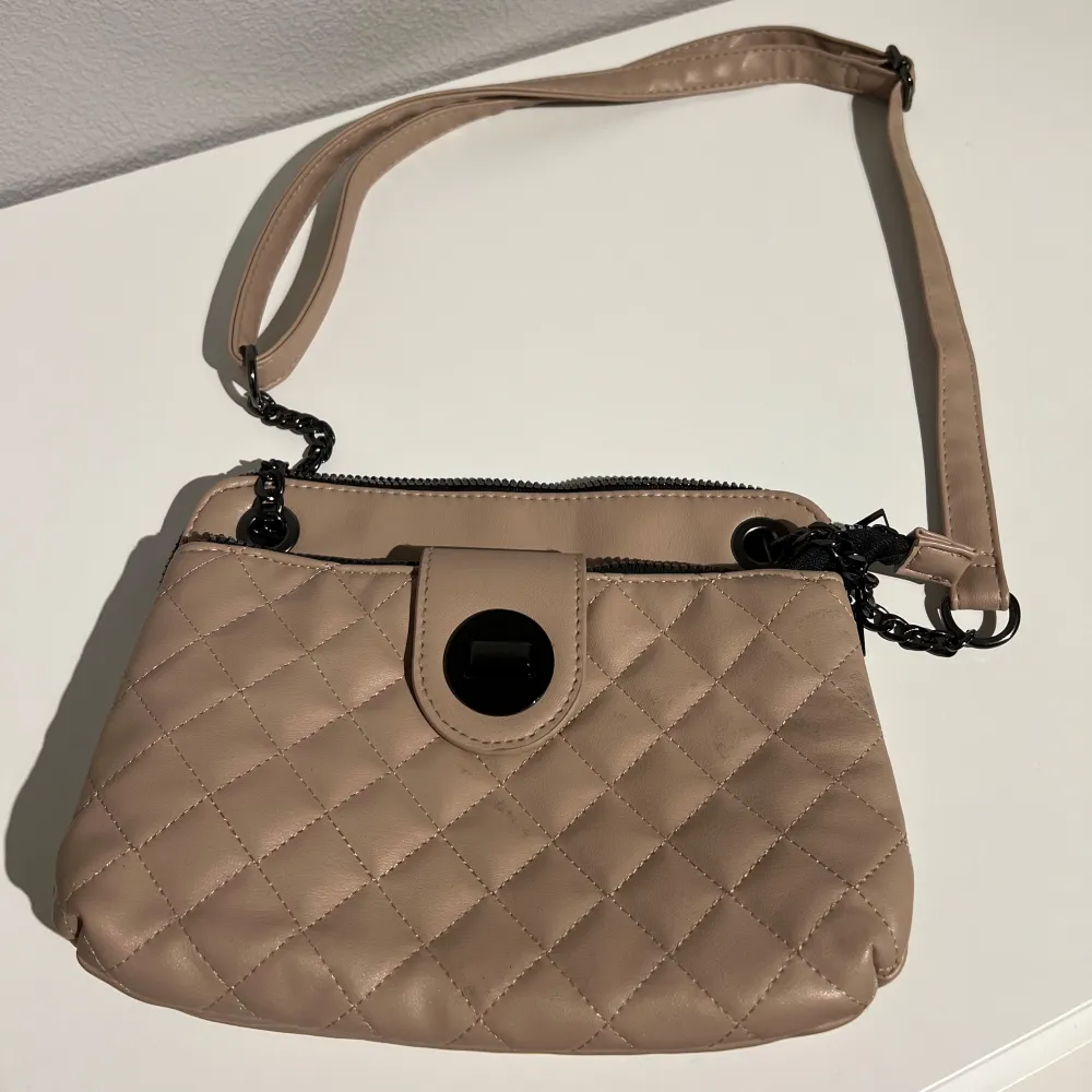 Säljer en beige/rosa handväska, med svart dragkedja och svarta detaljer som gör väskan väldigt elegant. Väskan är i bra skick utan några skador/slitningar och är från varumärket Primark. PRIS KAN DISKUTERAS!. Laukut & Käsilaukut.