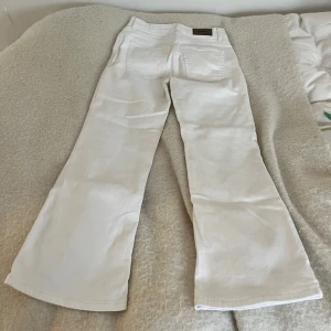 Vita bootcut jeans - Snygga vita bootcut jeans ifrån Dobber. Midjemått: ca 70 cm, innerbenslängd: 67 cm.
