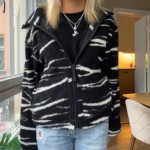 Svart och vit teddyjacka med zebramönster - Så fin svart och vit teddyjacka/flecee. Dragkedja och långa ärmar. Perfekt till våren och sommaren! Jackan är helt slutsåld. Inte mina bilder!!