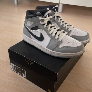 Nike Air Jordans i grått och vitt - Snygga Nike Air Jordans i en stilren grå och vit färgkombination. Skorna har klassisk snörning och en rund tå. Perfekta för dig som vill ha en ikonisk sneaker med en tidlös design.
