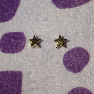 Stjärnformade örhängen i guld - Snygga stjärnformade örhängen i guldfärg. Perfekta för att lägga till lite stjärnglans till din outfit. De är små och diskreta, vilket gör dem lätta att bära varje dag. Inte använda men inte perfekta.