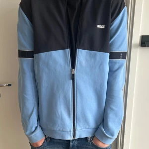 Ljusblå Hugo boss kofta - STORLEK L, ljusblå och blå med detaljer. Riktigt unik och snygg. Använd runt 5 gånger.