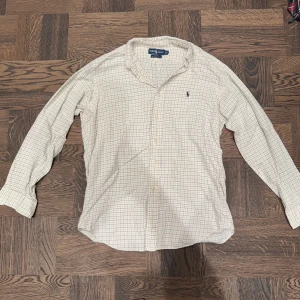 Ralph Lauren Skjorta - Super fin Ralph Lauren skjorta i bra skick! Skjortan har en unik stil med ett rutigt mönster i vitt och svart! Storlek S. Jackan har några få defekter (kolla bilder) Men kan lätt fixas! Har du några funderingar är det bara att skicka ett PM! Priset är ej hugget i sten! Mvh