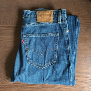 Levi's stay loose mellanblå W30 L32  - Säljer ett par klassiska blå jeans från Levi's med en loose passform. De har en traditionell femficksdesign och är tillverkade i slitstarkt denim. Perfekta för en avslappnad stil.
