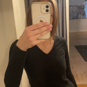 Svart långärmad tröja - Säljer en stilren svart långärmad tröja med v-ringning från lager 157. Perfekt för lager-på-lager eller som den är. Enkelt att matcha med olika outfits. Lappen med storleken har gått sönder men är i storlek S/M ungefär.💕