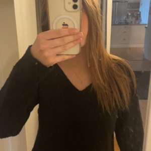 Svart stickad tröja med v-ringning - Säljer en stilren svart stickad tröja med v-ringning. Tröjan har långa ärmar och är perfekt för en enkel och klassisk look. Passar bra till både jeans och kjol. Köpt på lager 157.💕