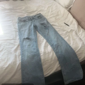 Low waist Ljusblå jeans med slitningar - Snygga ljusblå jeans med slitningar på låren 
