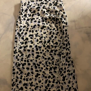 Leopardmönstrad kjol  - Snygg leopardmönstrad kjol från Aware by Vero Moda. Kjolen har en elastisk midja och ett knytband framtill för extra stil. Perfekt för att ge din outfit en trendig touch. 🐆