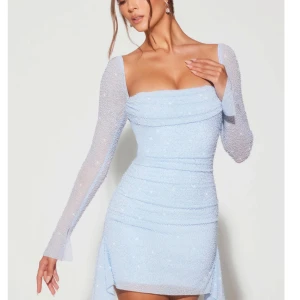 Ljusblå glittrig klänning - Snygg ljusblå klänning med glittrande detaljer och långa ärmar. Den har en tight passform och en elegant design som passar perfekt för festliga tillfällen. Använd endast 1 gång. Pris kan diskuteras vid snabb affär. Från Oh Polly