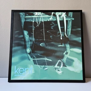 Kent - Albumaffisch, 31.5x31.5cm - Kent - Den döda vinkeln albumaffisch, 31.5x31.5cm   Helt ny - Passar bra i IKEAs tavelram Lomviken!  Tryckt på glossy 240gr papper  Skickas i papprulle - Ramen ingår inte!