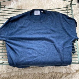 Merinoull tröja - Säljer en stilren blå merinoull tröja från Bläck i storlek M. Tröjan har en klassisk rund halsringning och långa ärmar. Perfekt för en avslappnad och snygg look.