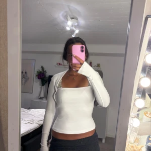 Vit långärmad topp från Zara - Säljer en vit långärmad topp från Zara med tight passform och fyrkantig ringning. Tröjan är ribbad och har långa ärmar! Aldrig använd 