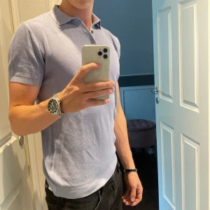 Ljusblå pikétröja Massimo Dutti - Säljer en stilren ljusblå pikétröja från Massimo Dutti i nyskick!! Materialet är bomull med en diskret struktur som ger en snygg touch. Perfekt för dig som gillar en clean och fräsch look! Hör av er vid minsta frågor! Pris kan diskuteras!🍾