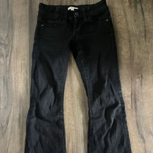 Svarta jeans från Gina Tricot - Svarta jeansbyxor från Gina Tricot i klassisk femficksmodell. Byxorna har raka ben, snygga bakfickor med lock och knappdetalj samt bälteshällor. Perfekta för dig som gillar en enkel och stilren look. Dom har används men är fortfarande i fin form!💕