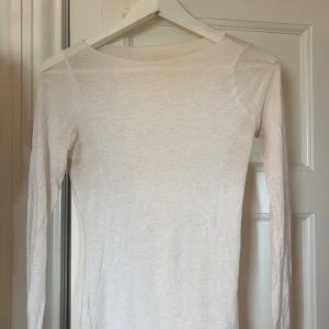 Vit intimissimitröja i bomull - En enkel och stilren vit intimissimitröja i mjuk bomull. Tröjan har rund halsringning och en tight passform som funkar perfekt till lager-på-lager eller som basplagg.
