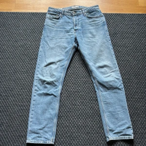 Jack & Jones Loose Chris ljusblå jeans - Ljusblå jeans från Jack & Jones i modellen Loose Chris. Klassisk femficksdesign, raka ben och avslappnad passform. Tillverkade i bomull med snygg tvättad look och kontrastsömmar. Perfekta för en chill och avslappnad stil.