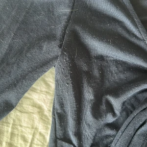 Mörkblå knyttopp från Gina Tricot - Trendig mörkblå omlottopp med långa ärmar och snygg knytning framtill. Djup v-ringning och croppad, lite nopprig på bröstet och vid armhålan men ingenting man tänker på. Använd max 10 gånger, köp gärna 🩷