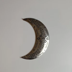  halvmåne med mönster - Vägg dekor i form av en halvmåne i silverfärgad metall. Månen har graverade geometriska mönster och pilar över hela ytan. Meddela gärna för mått eller andra frågor☺️
