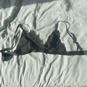 Svart spetsig bralette  - Säljer en svart bralette med spetsdetaljer och justerbara axelband. Toppen har triangelformade kupor och bred resår under bysten för extra stöd. Jätteskön och bra att ha under något om man vill ha något lite lättare. Den är från hm men har klippt bort lappen så tror att den är storlek s men skulle kunna vara xs också🫶