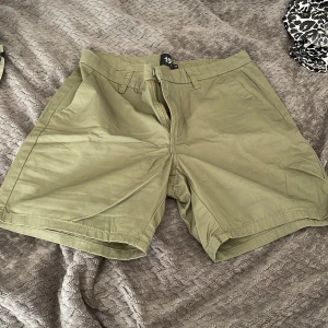 Olivgröna shorts från 157, XS - Olivgröna shorts från 157 i klassisk modell med fickor fram och bak, bälteshällor och dragkedja. Perfekta för varma dagar och har en enkel, stilren look. Tillverkade i mjuk bomull som känns skön mot huden. Står xs men passar mig som har S❤️
