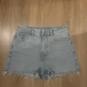 Ljusblå jeansshorts med fransar - Shorts från bikbok i strolek S, de har en klassisk femficksdesign och är högmidjade för en bekväm passform. (Shorts är oanvända)